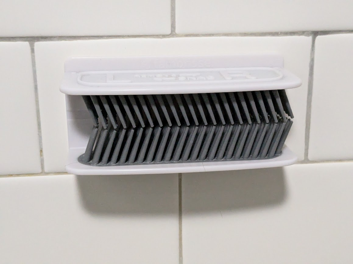 photo of hair grabber on tile shower wall